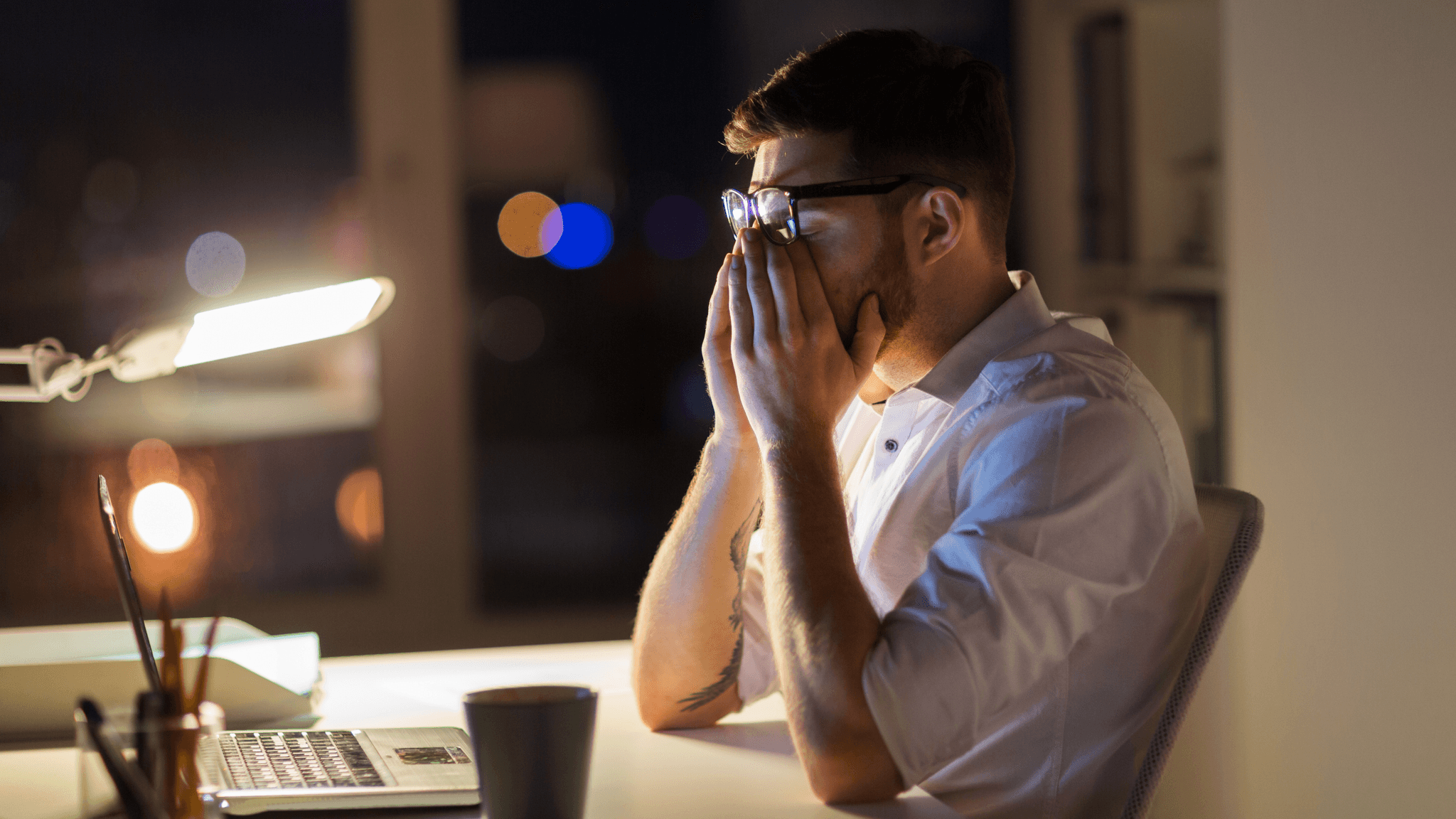 Person som føler seg trøtt og sliten ved skrivebordet etter jobb