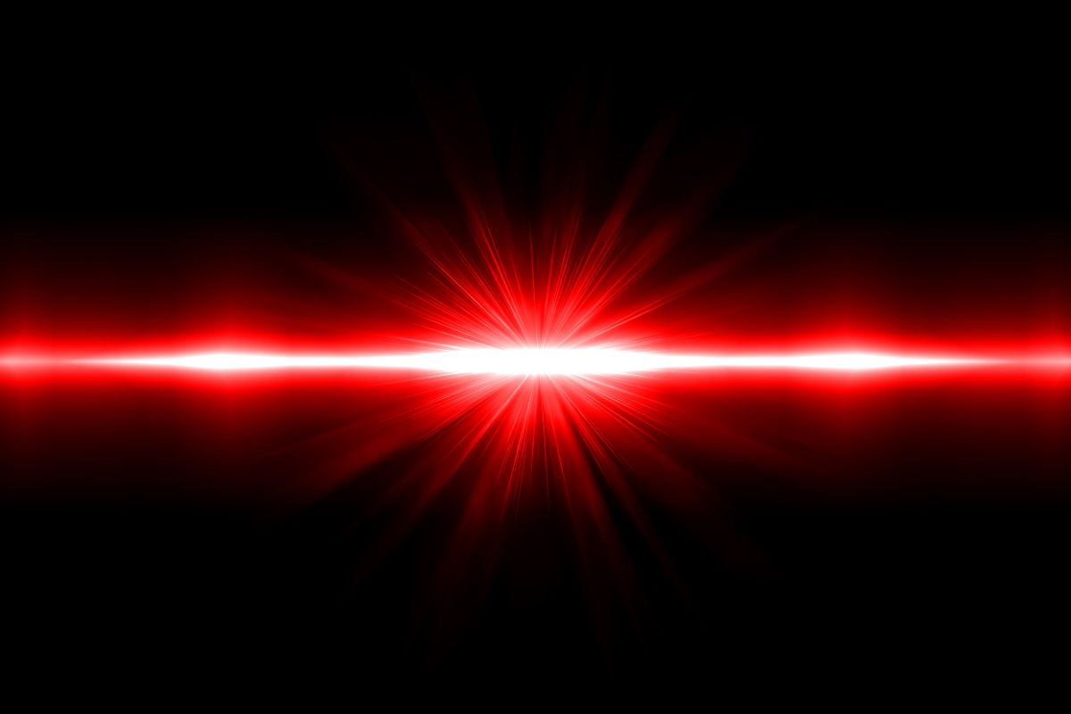 a red thread of light shines brightly in front of a black background