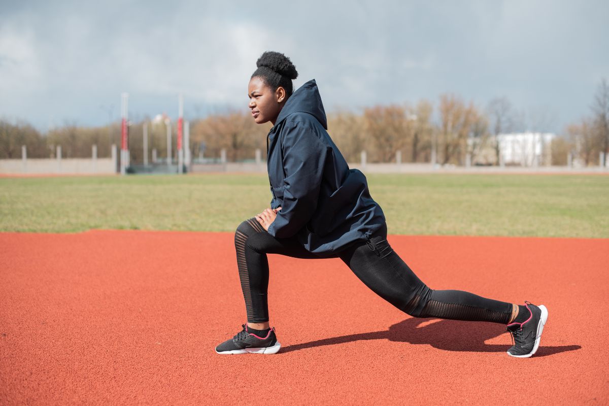 a woman does a lunge in the middle of a track